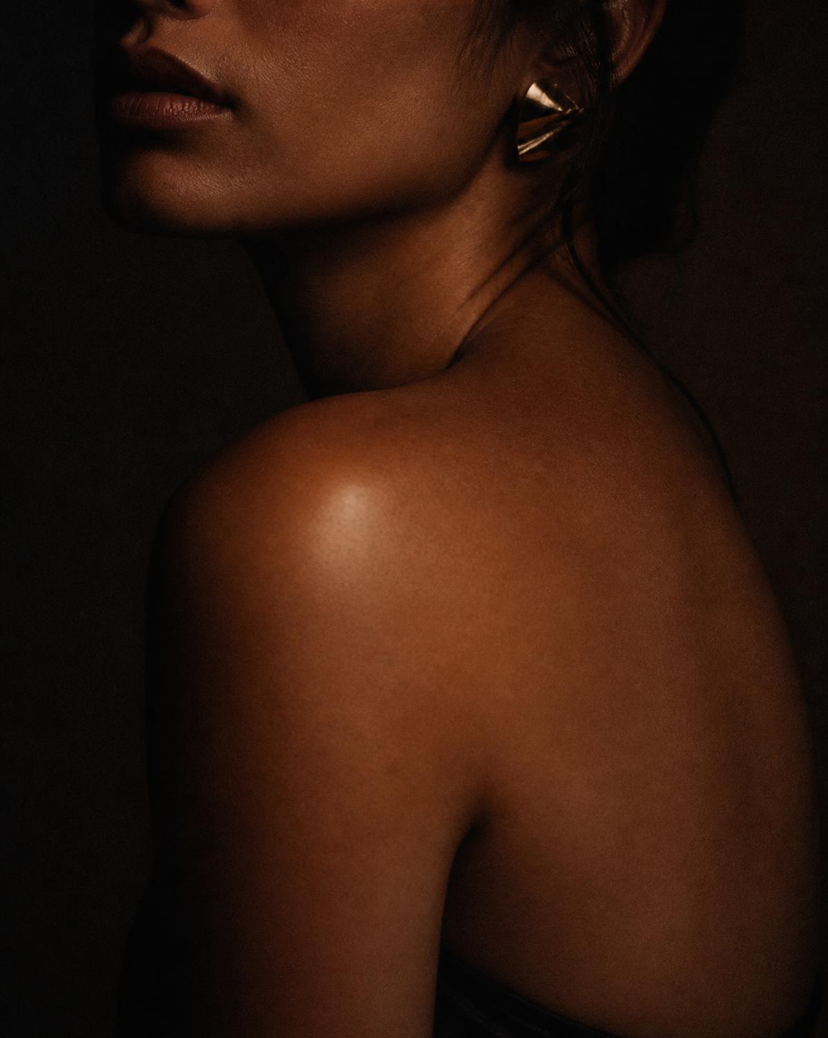Low-light editorial beauty portrait in warm shadow